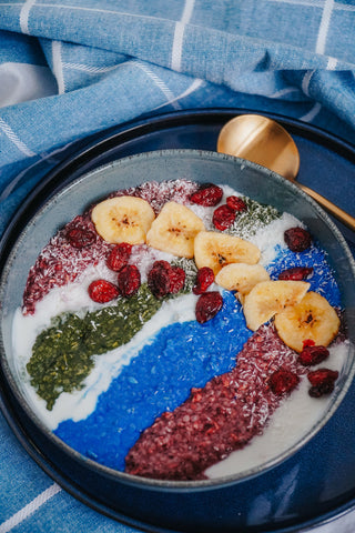 Smoothie bowl with blue spirulina, chlorella, berries, banana chips, and coconut flakes