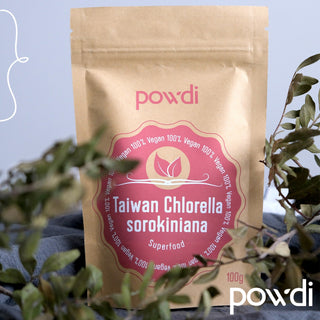 Taiwan Chlorella sorokiniana vegan superfood in brown pouch with leaves in foreground