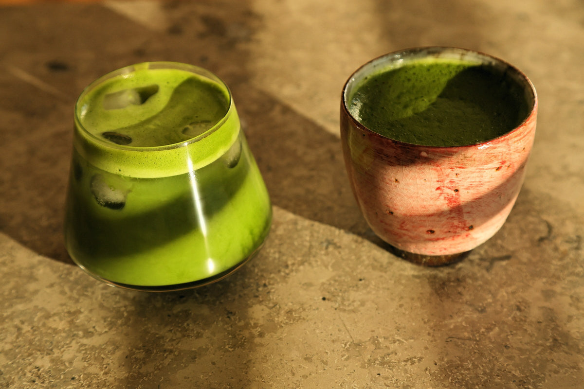 Ledinė ir karšta matcha latte su migdolų pienu ant akmeninio stalo