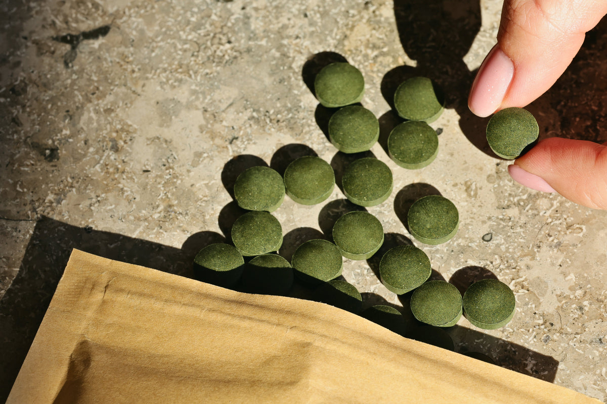 Spirulinos ir chlorellos tabletės ant akmens