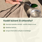 Chlorellos milteliai šaukštelyje virš stiklinės vandens